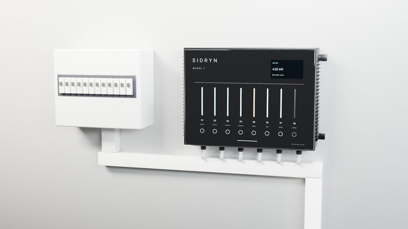 A Sidryn unit mounted on a wall beside a household fuse box